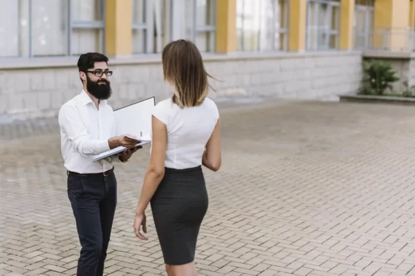 Man submitting documents to woman